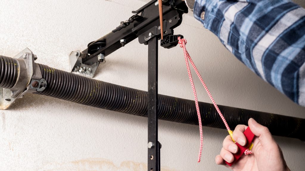 A homeowner lubricating the emergency cord spring