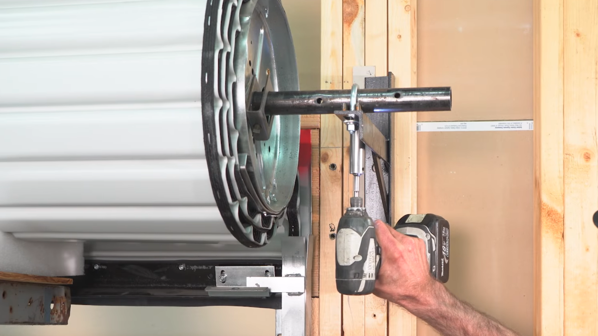 A garage door technician adjusting the roller door alignment