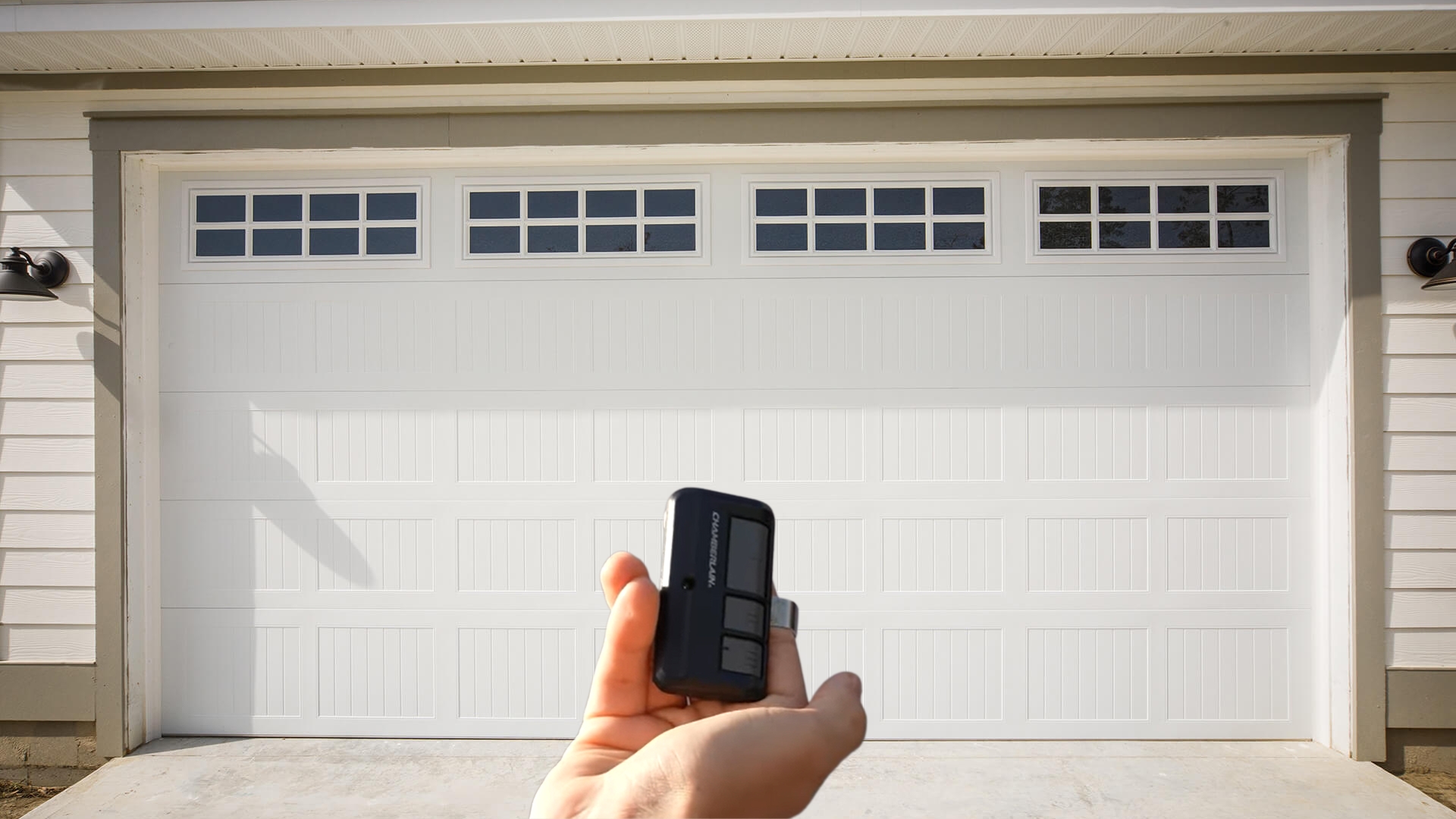 A man holding a garage door remote control