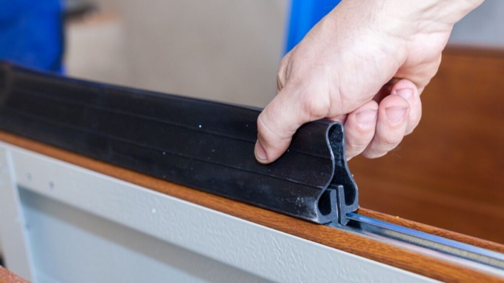 A man installing new garage door weather seal