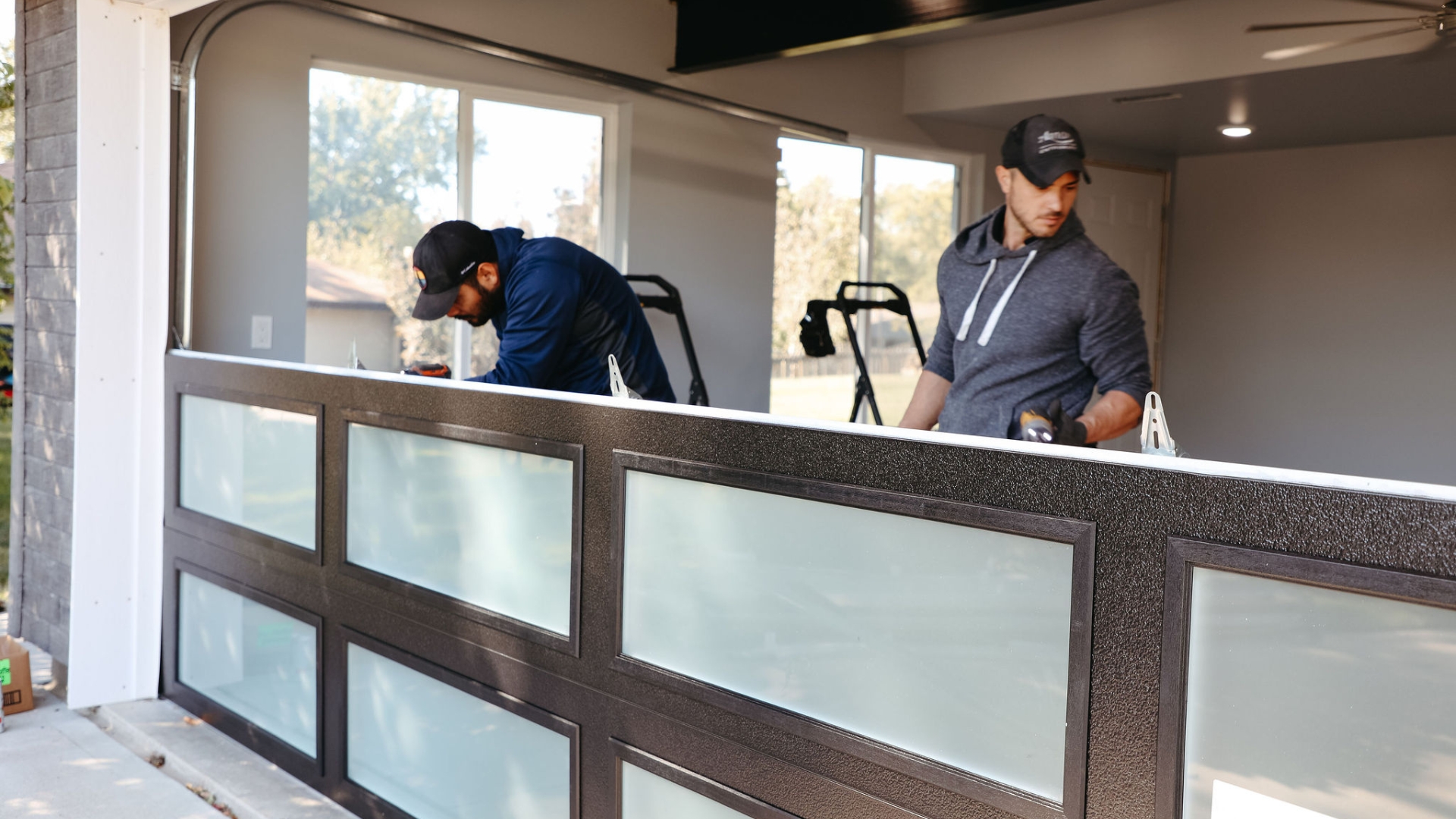 Two garage door technicians installing a new garage door