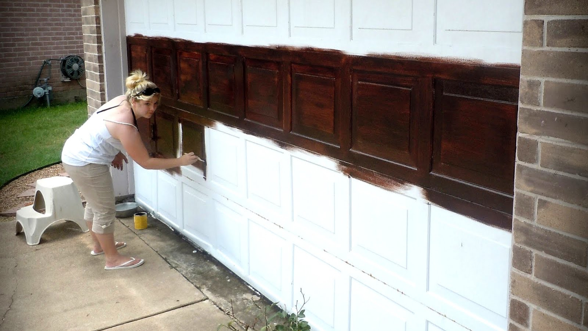 A woman applying the right amount of garage door paint on their wooden door