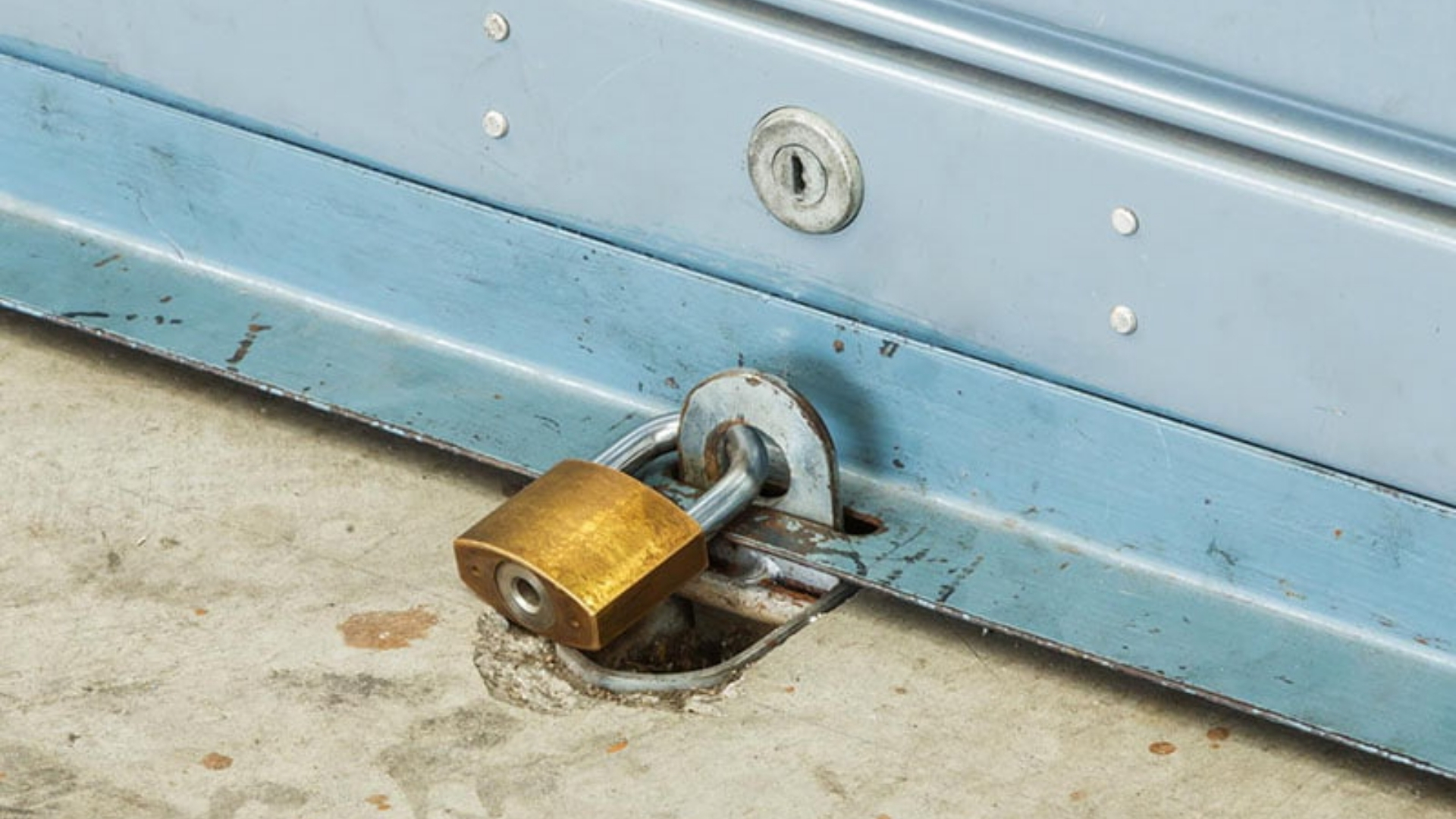 Close view of garage door padlock securing system.