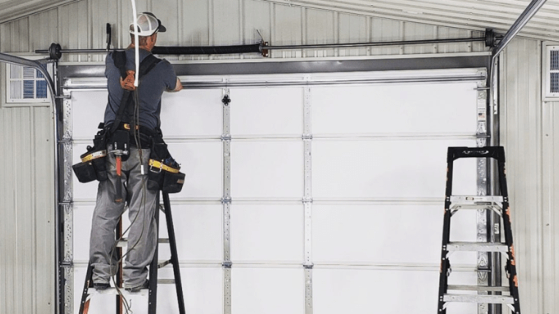 A technician doing a final check on the garage door tracks he installed