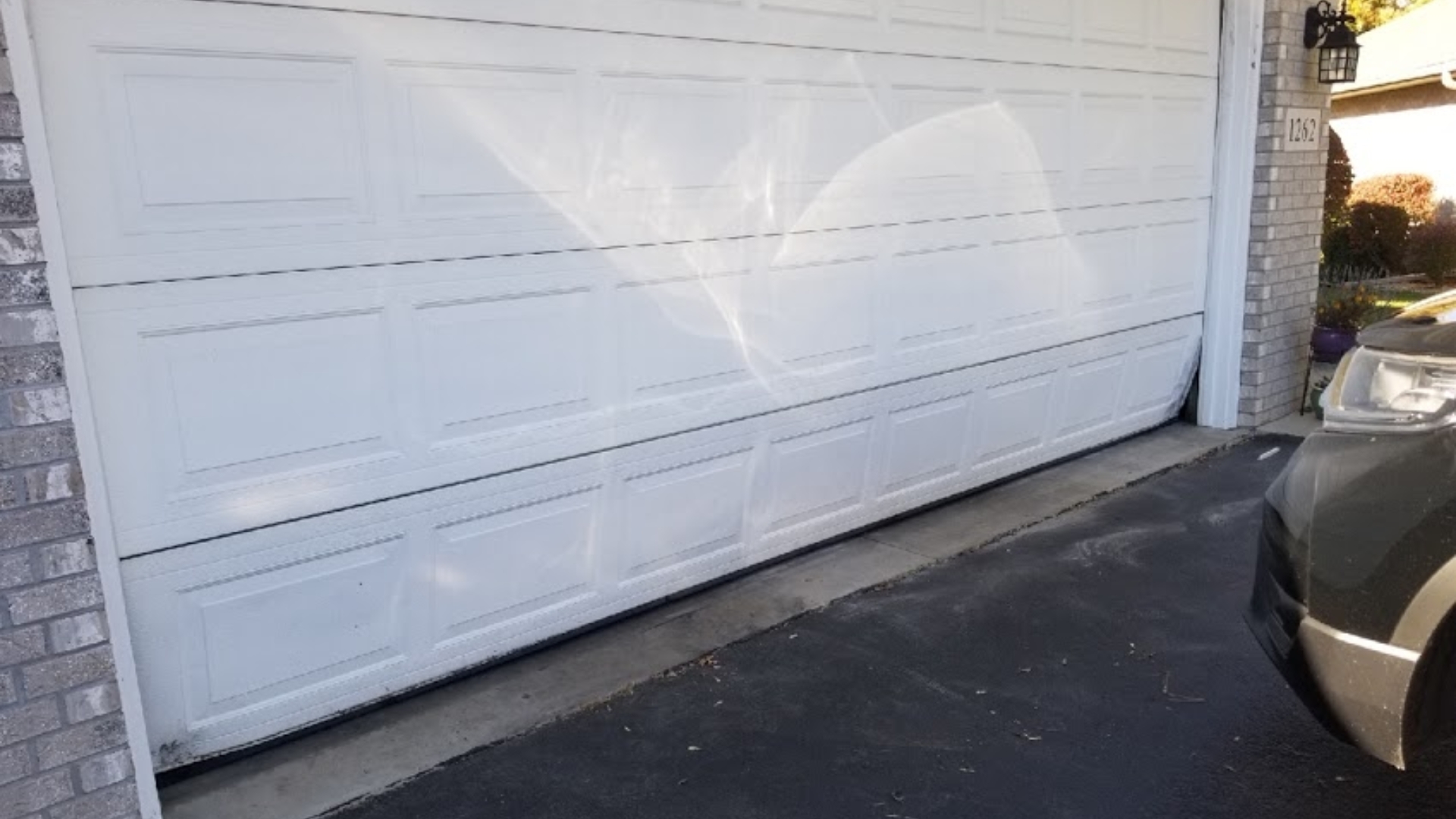 A garage door with damaged panels needing a replacement