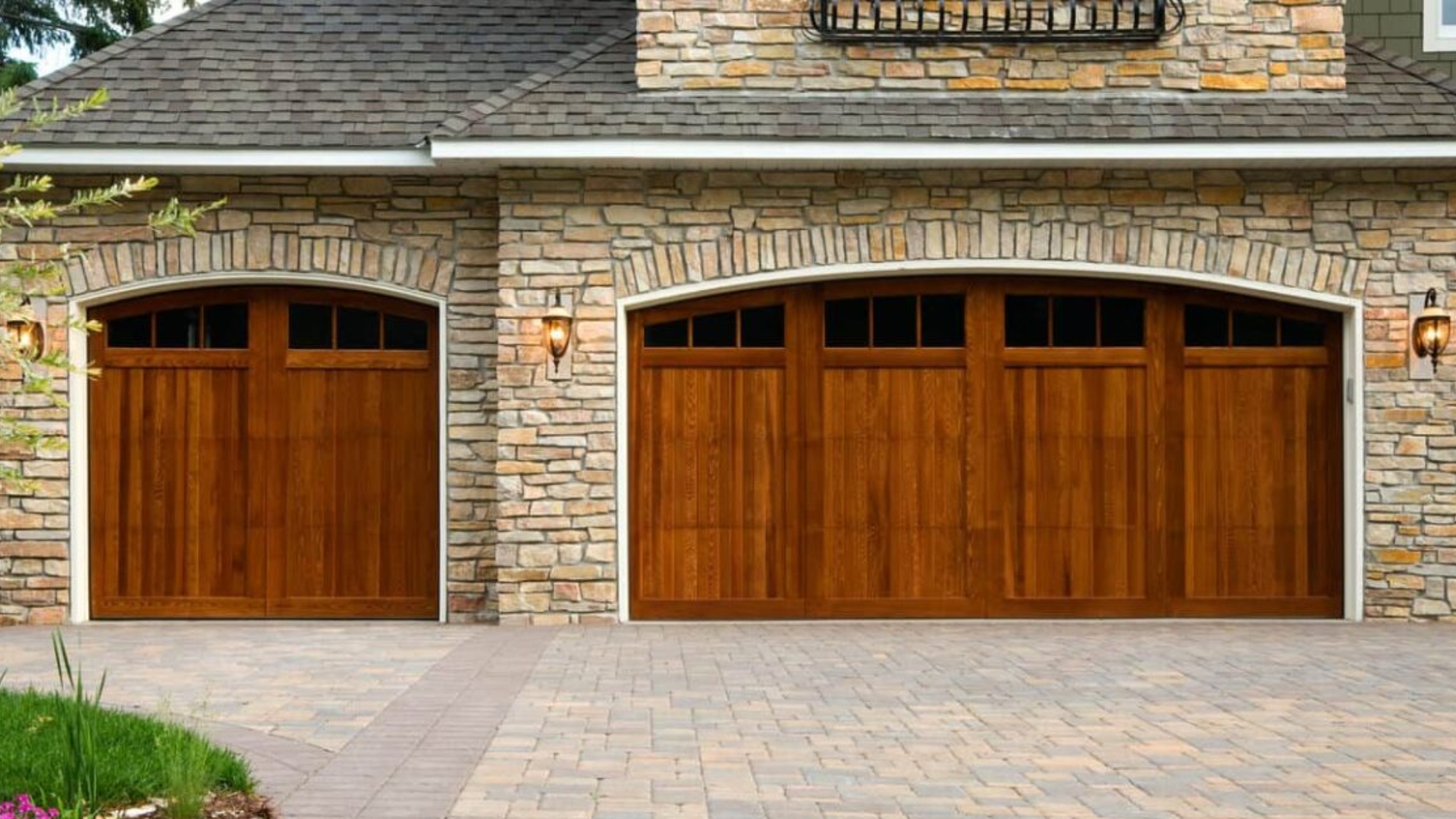 Two wooden garage doors with a natural finish complementing the stone facade.