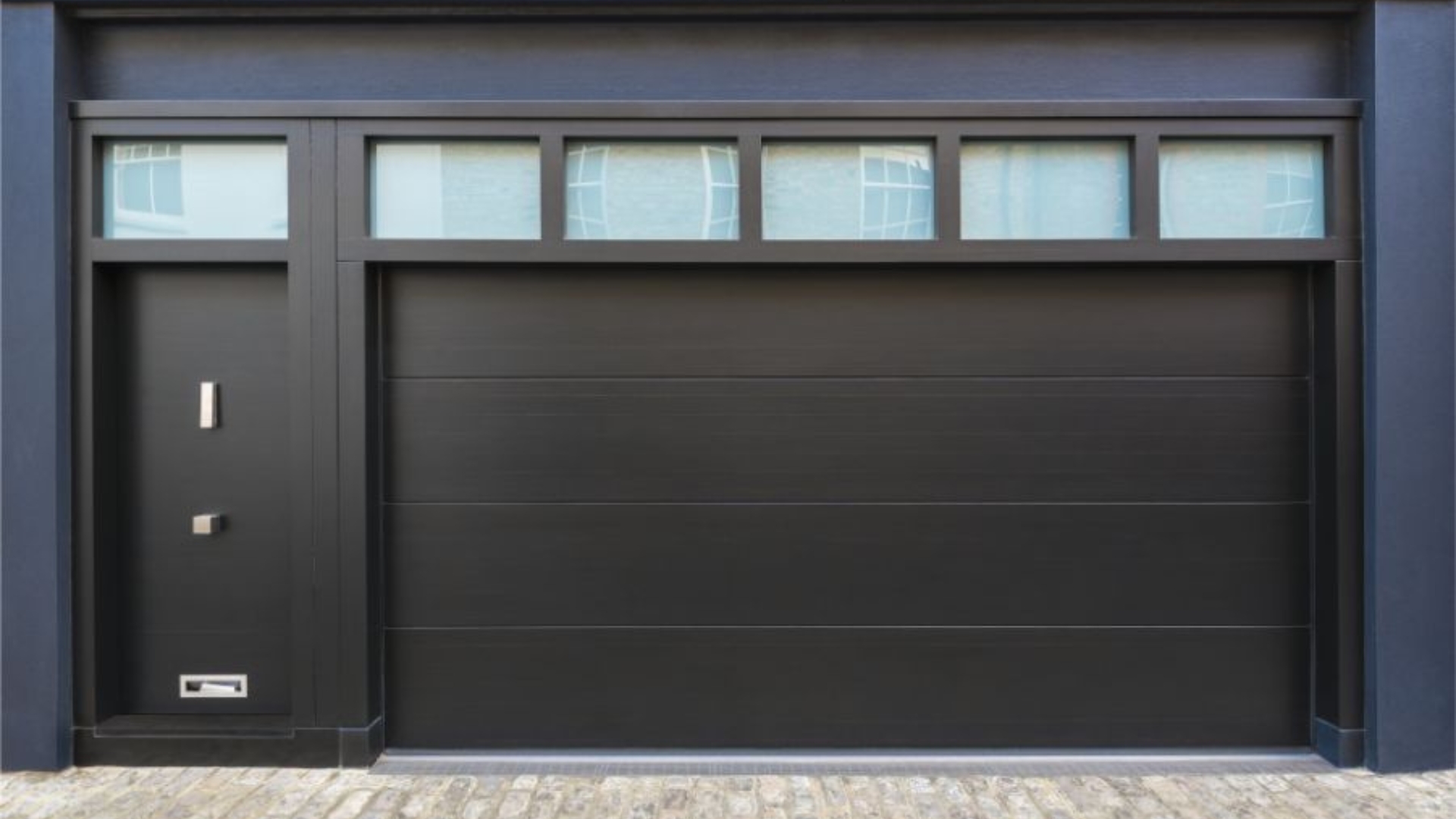 Dark garage door with sectional panels and glass windows.