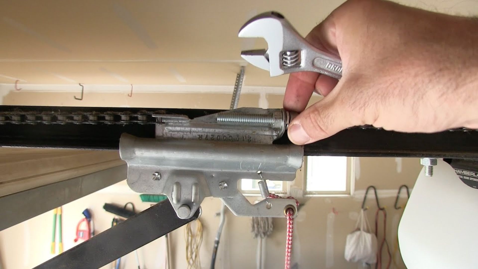 Tightening the garage door chain to fix a garage door that won’t close.